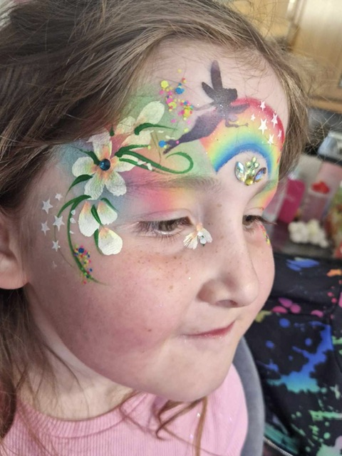 Girl with a rainbow fairy face paint in Telford